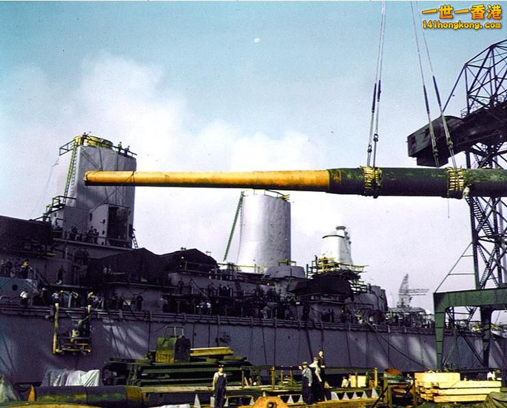 Yard workers hoist one of nine 16_50 Mark VII gun barrels aboard the USS Iowa du.jpg