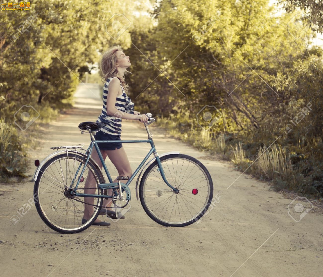 15760214-beautiful-smiling-girl-with-a-bicycle-on-the-road-Stock-Photo-fashion-b.jpg