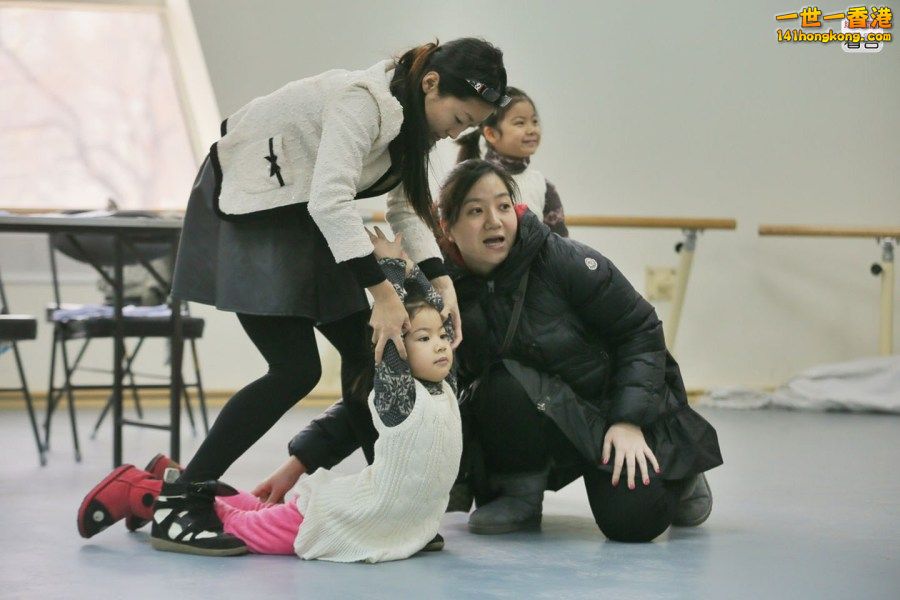 8 北京少年宫報名火爆 舞蹈面試中，家長幫助孩子展示柔韌度.JPG