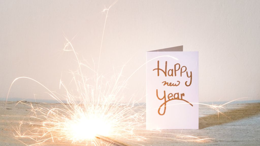 new-year-card-with-lit-sparkler-on-table-against-wall-688969401-5bd668bc46e0fb00.jpg