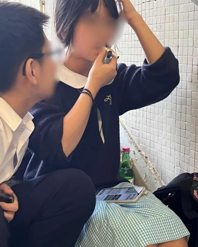 女生咬着香煙，右手拿着打火機，身旁還擺放了一支疑似韓國燒酒。.jpg