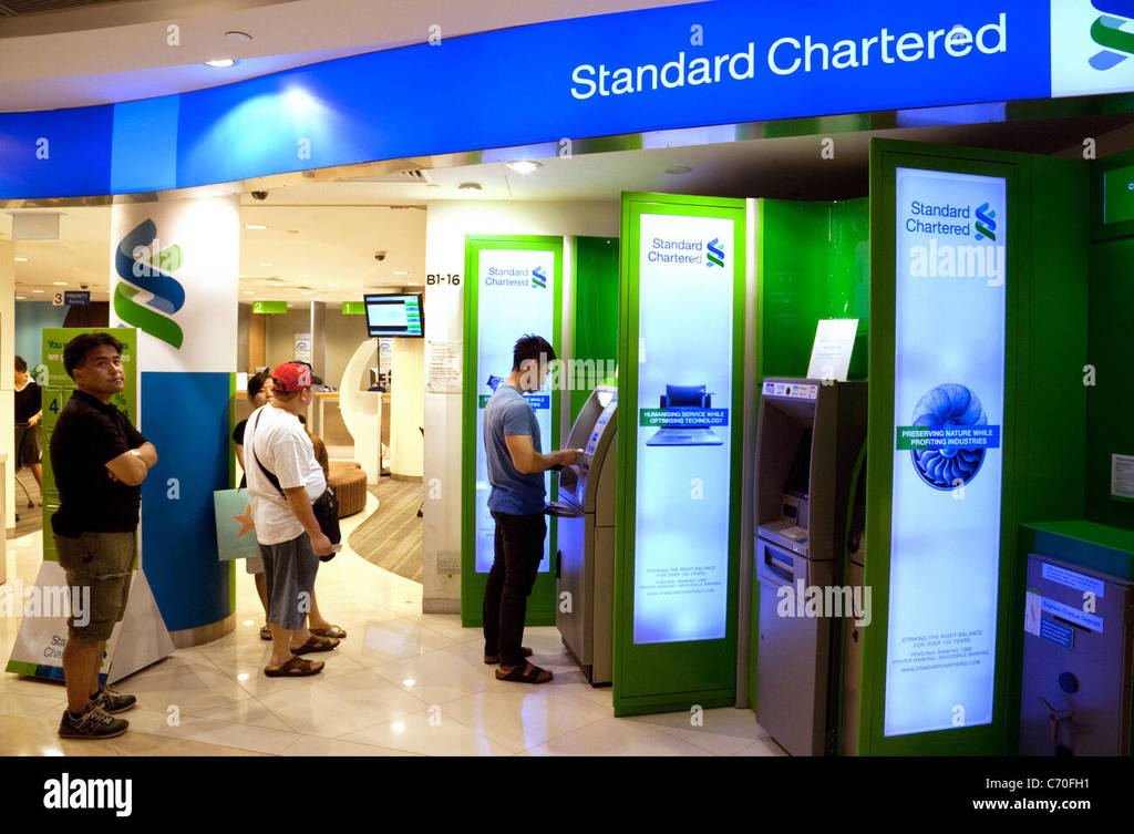 people-getting-cash-from-a-standard-chartered-bank-atm-in-singapore-C70FH1.jpg